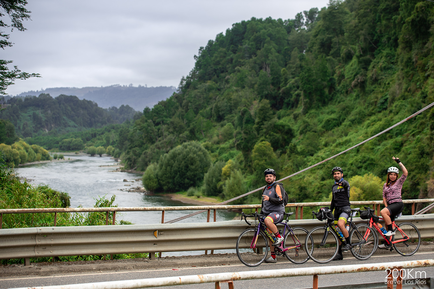 Ciclistas saludando a la cámara desde el puente